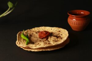 A pita bread with a green pepper on top of it